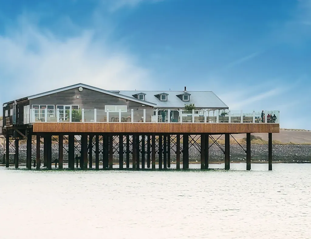 Nowoczesna restauracja z widokiem na Morze Północne w Holandii, położona bezpośrednio na piaszczystej plaży.