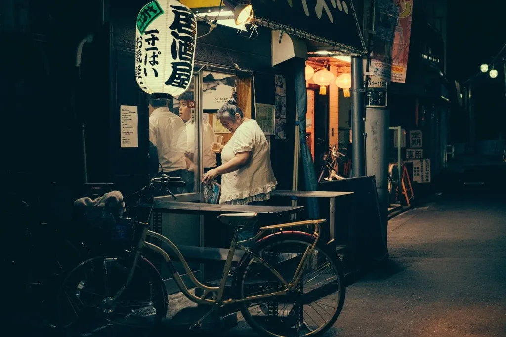 Tętniąca życiem restauracja przy oświetlonej nocą ulicy w Tokio.